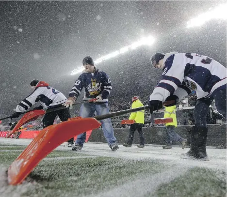  ?? PAUL CHIASSON/THE CANADIAN PRESS ?? Workers diligently remove snow from the lines before the 105th Grey Cup in Ottawa on Sunday.