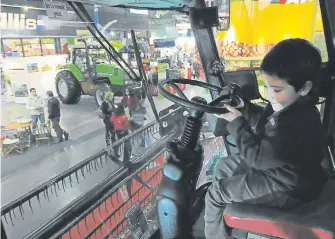  ??  ?? Fierreros. Los chicos aprovechan todos los años para ver la maquinaria agrícola en plena Capital.