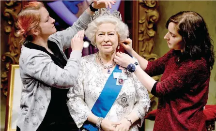  ?? — AFP ?? Stylists Jane Anderson (L) and Luisa Compabassi with the re-styled wax figure of Queen Elizabeth II at Madame Tussauds in central London.