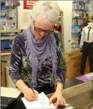  ??  ?? Chrissie Harpur totting up the old fashioned way with pen and paper in Wallaces SuperValu, Wellington­bridge.