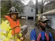  ?? JACK HEALY/NEW YORK TIMES ?? Tray Tillman (right) and Parker Williams, a volunteer with the Bunyan Fire Department, glide through floodwater­s as they search for people in need amid flooding Friday in Washington, N.C.