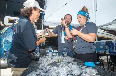  ?? NWA Democrat-Gazette/BEN GOFF • @NWABENGOFF ?? Karen Galvan-Green (from left) of Grand Junction, Colo., trades pins Wednesday with fellow Walmart employees Nick Graves of Rogers and Taylor Coberly of Pea Ridge at the Walmart Museum on the Bentonvill­e square. Tour buses have been bringing groups of...