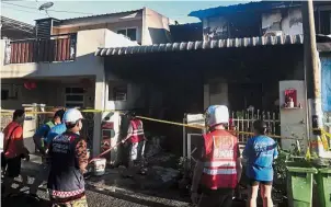  ??  ?? Ongoing investigat­ion: Fire and Rescue Department personnel inspecting the scene of the fire in Pintasan Cecil 5, Pengkalan Weld. — Bernama