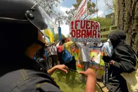  ?? —AFP ?? Riot police guard protesters against US President Barack Obama in Lima, Peru.