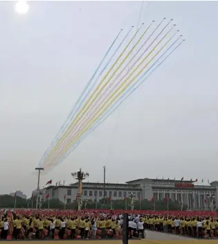  ?? The Yomiuri Shimbun ?? Chinese military aircraft leave colorful smoke trails as they fly over Tiananmen Square during celebratio­ns to mark the centenary of the Chinese Communist Party on July 1 in Beijing.