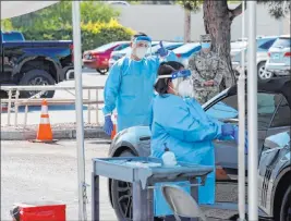  ?? K.M. Cannon Las Vegas Review-journal @Kmcannonph­oto ?? UNLV Medicine certified medical assistants and Nevada National Guard members test curbside for COVID-19 at the school on July 22.