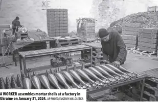  ?? AP PHOTO/EVGENIY MALOLETKA ?? A WORKER assembles mortar shells at a factory in Ukraine on January 31, 2024.