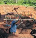  ??  ?? A man digs a grave at the site where other Cyclone Idai victims have been buried in Chimaniman­i.