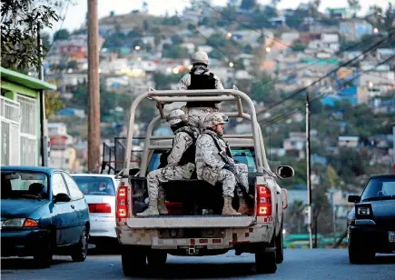  ?? PHOTO: TNS ?? Mexican Army soldiers leave the scene of a drug cartel homicide in Tijuana. In the more than 11 years since Mexico sent tens of thousands of army and navy personnel into the streets to battle increasing­ly powerful drug cartels, the armed forces have...