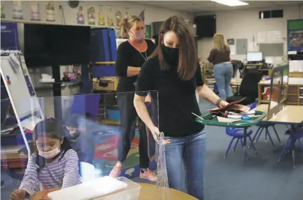  ?? Lea Suzuki / The Chronicle ?? Teacher Liz Duffield ( center) hands out art materials in her classroom at Lu Sutton Elementary School in Novato.