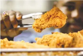  ?? ASSOCIATED PRESS FILE PHOTO ?? A cook serves up a piece of fried chicken. Tennessee cities eat quite unhealthil­y compared to the rest of country, according to a Gallup-Sharecare survey, which includes rankings for Chattanoog­a, Kingsport, Clarksvill­e, Greater Nashville, Memphis and Knoxville.