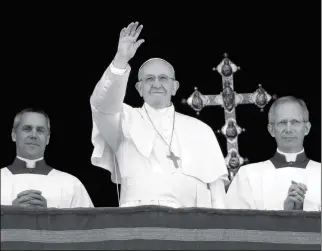  ?? ASSOCIATED PRESS ?? POPE FRANCIS, FLANKED BY MASTER OF CEREMONIES BISHOP Guido Marini, waves to faithful during the Urbi et Orbi (Latin for “to the city and to the world”) Christmas day blessing from the main balcony of St. Peter’s Basilica at the Vatican on Monday.