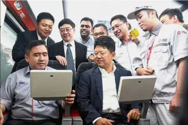  ??  ?? ‘Rail’ diplomacy: Loke and Bai Tian trying out features in the new KTM electric train service business class coach which is expected to be launched soon.