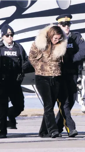  ?? PAUL CHIASSON / THE CANADIAN PRESS ?? RCMP officers on Monday escort a suspect in an alleged money-laundering network off an airplane in St-Hubert, Que.