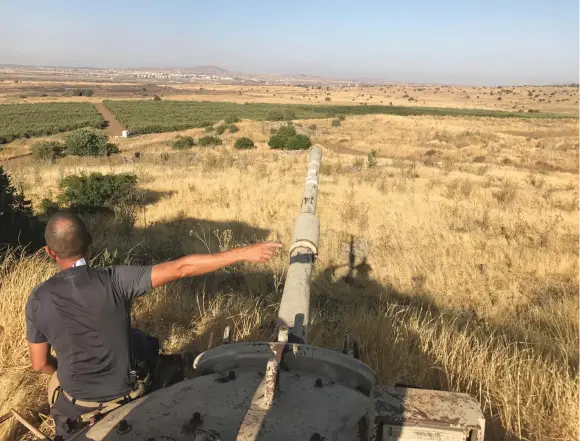  ??  ?? A GOLAN resident sits on a rusted tank from the 1973 war on the Golan border overlookin­g Syria.