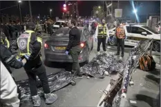  ?? AP photo ?? Victims of a shooting attack are covered on the ground near a synagogue in Jerusalem on Friday. Israel’s national rescue service Mada says a gunman killed five people and wounded three others in a shooting near a synagogue Friday night in east Jerusalem in one of the deadliest attacks on Israelis in years. The gunman was shot and reportedly killed.