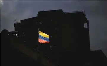  ??  ?? A Venezuelan flag is seen in downtown Caracas, Venezuela. -- Reuters photo