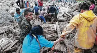  ?? Colombian Army via Associated Press ?? Soldiers and rescue workers on Saturday evacuate residents from the area in Mocoa, Colombia, after an avalanche of water from an overflowin­g river swept through the city, destroying it as people slept. In addition to at least 193 killed, 202 were...