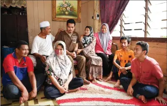  ?? — Bernama photo ?? Azizah (fourth right) poses for a photo with her husband and six of her 12 children at their home.