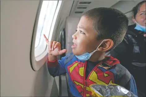  ?? (AP Photo/Julio Cortez) ?? Yancarlos Amaya, 5, a migrant from Honduras, looks out an airplane window in Harlingen, Texas, as he and his mother, Celestina Ramirez, ride on an airplane to Houston on March 24. The mother and son, who were headed to Baltimore to reunite with Ramirez’s brother, were permitted to stay in the U.S. after turning themselves in to U.S. Customs and Border Protection upon crossing the border.