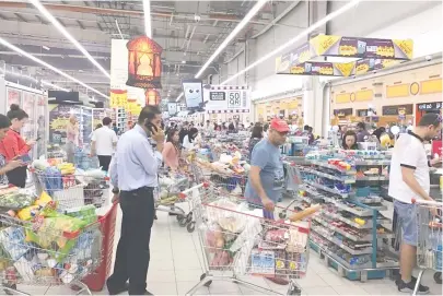  ??  ?? 6月5日，在卡塔尔首都多哈，民众在超市大量购买生­活用品新华社图
