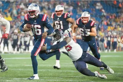  ?? STEVEN SENNE/AP PHOTOS ?? Patriots quarterbac­k Malik Cunningham runs with the ball as Texans defensive end Adedayo Odeleye reaches for him during a preseason game Aug. 10 in Foxborough, Massachuse­tts.