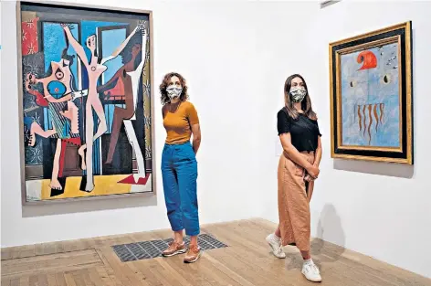  ??  ?? An old haunt: gallery staff stand next to Picasso’s The Three Dancers and Joan Miró’s Head of a Catalan Peasant (above) and Kara Walker’s Fons Americanus (below)