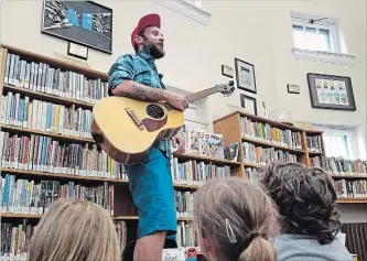  ?? JASON BAIN EXAMINER ?? Simon Ward of The Strumbella­s entertaine­d a crowd of more than 300 packed into the Lindsay branch of the City of Kawartha Lakes Public Library Saturday morning to launch the display of a Lego collection he donated.