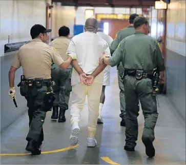  ?? Mark Boster Los Angeles Times ?? A REPORT found that the average suicide rate at California prisons was 22 per 100,000 inmates, compared with 15.66 per 100,000 in other states. Above, two inmates are escorted at Pelican Bay State Prison in 2013.