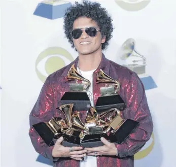  ?? FOTO: AFP ?? Trägt schwer am Erfolg: Bruno Mars, beladen mit sechs Grammys.