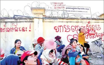  ?? PHA LINA ?? Benoh Apparel workers sit outside the abandoned factory in January. Workers from Benoh and three other factories have complained about compensati­on packages provided to them by the government.