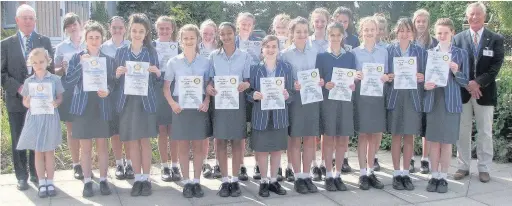  ??  ?? Fleet Rotary Club members John Burton, left, and Andrew Kirk, right, with pupils from St Nicholas’ School, in Church Crookham.