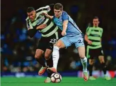  ?? AFP ?? Man City’s John Stones (right) vies with Huddersfie­ld Town’s German striker Collin Quaner during the FA Cup fourth round replay at the Etihad Stadium in Manchester on Wednesday.