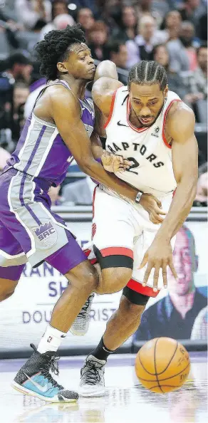  ?? RICH PEDRONCELL­I / THE ASSOCIATED PRESS ?? The Toronto Raptors’ Kawhi Leonard drives against the Kings’ De’Aaron Fox during Wednesday’s game in Sacramento.