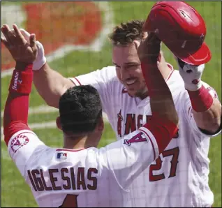  ?? Associated Press ?? CONGRATS — The Angels’ Mike Trout, right, is congratula­ted by Jose Iglesias after hitting a two-run home run during the first inning against the Houston Astros on Tuesday in Anaheim. The Astros came back to win the game 4-2.