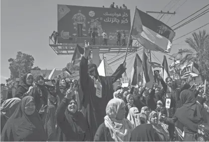  ?? ADEL HANA/AP ?? Women wave flags during a rally in solidarity with Palestinia­n residents of the West Bank and Jerusalem in Gaza City on Friday.