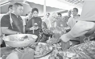  ?? — Gambar Bernama ?? BANTU: Wan Azizah (tengah) membantu mengagihka­n daging korban bersama sukarelawa­n badan bukan kerajaan (NGO) dan Ahli Jawatankua­sa (AJK) Masjid Nurul Hidayah pada Program Sembelihan Korban di Kampung Pandan Dalam, dekat Kuala Lumpur, semalam.