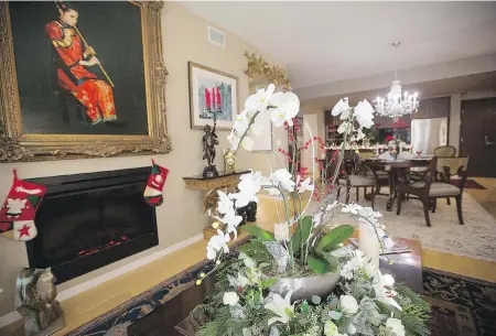  ??  ?? A winter garden of orchids rests amid a wreath of roses and lilies. Stockings by the electric fireplace are ready to be filled for the owner’s grandsons.