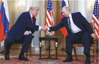  ??  ?? Trump and Putin shake hands as they meet in Helsinki on Monday.