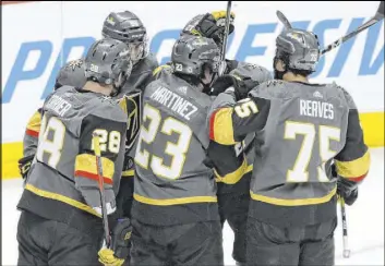  ?? Joe Mahoney The Associated Press ?? It’s almost a group hug after William Carrier’s third-period goal forges a 2-2 tie and sets the stage for a Golden Knights’ overtime victory against the Avalanche.