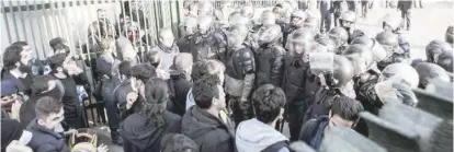  ??  ?? Iranian students scuffle with police at the University of Tehran during a demonstrat­ion on December 30