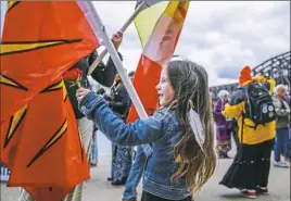  ?? Andrew Rush/Post-Gazette ?? Naomi Neri, 5, of Indianapol­is, hands a rose to another member of her group during the “Defend Our Water” rally Wednesday..