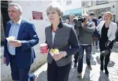  ?? — AFP ?? Prime Minister Theresa May carries a portion of chips whilst meeting with residents in Mevagissey, south-west England, on Tuesday, during a campaign visit ahead of the forthcomin­g elections.