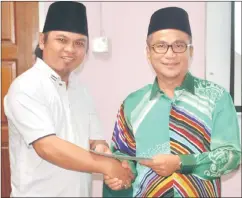  ??  ?? Mohamad Safree (left) represents Surau Darul Sa’adah of Kampung Pa’ Dris to accept the contributi­on from Dr Annuar.