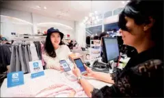  ?? XU KANGPING / FOR CHINA DAILY ?? An outbound Chinese tourist pays with Alipay at the checkout of a shopping mall in Sydney.