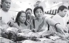  ?? GETTY IMAGES ?? Customers are seen choosing ham to buy from a store in Quiapo, Manila.