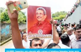  ??  ?? COLOMBO: Supporters carry placards with a picture of Gotabhaya Rajapakse, former secretary to the ministry of defense and brother of Sri Lanka’s opposition leader and former president Mahinda Rajapakse in Colombo. — AFP