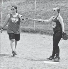  ?? SARA ERICSSON ?? Amanda Dabis hands the bat to a member of the opposing team. She said the presence of the fallen officers is felt on the field when they play.