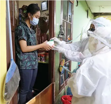  ?? FEDRIK TARIGAN/JAWA POS ?? GRATIS: Nakes dari Puskesmas Tanjung Priok membagikan obat kepada warga yang isoman di Sunter Jaya, Jakarta Utara, kemarin (15/7).