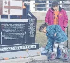  ?? ADAM MACINNIS/THE NEWS ?? A student lays an orange carnation in honour of one of the residentia­l school survivors during a ceremony held Friday at Pictou Landing First Nation.